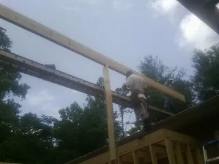 Carpenter setting a ridge beam over a new addition frame — Ice Dam Removal by Roofing Brothers in Mapleton Depot