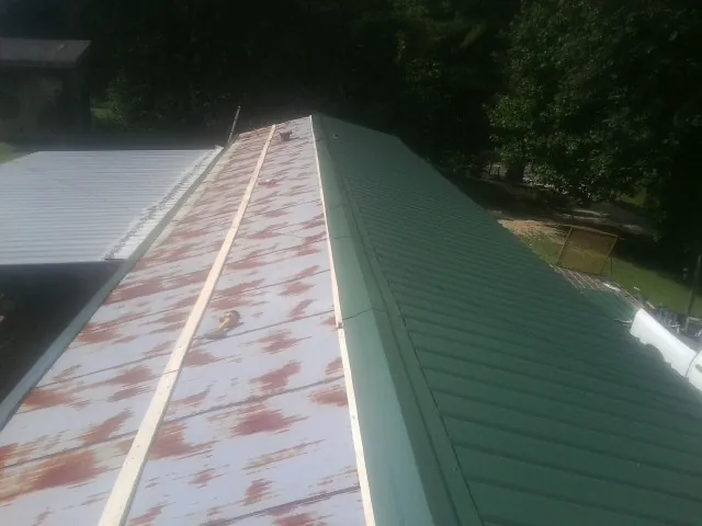 Old rusted panels beside newly installed green metal roofing — Wind Damage Roof Repair by Roofing Brothers in Mapleton Depot