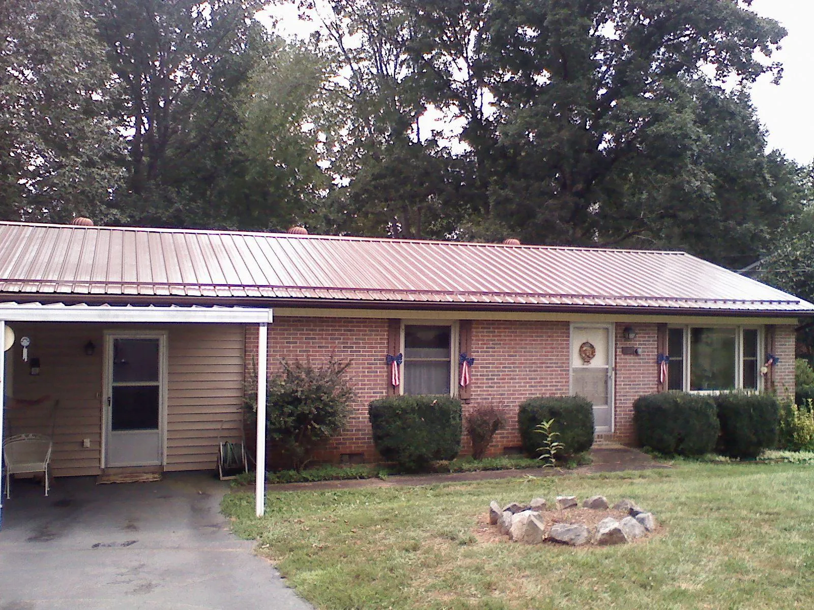 Bronze metal roof and carport on a brick ranch home — Roof Repair work by our crew in Mapleton Depot